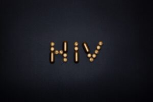 Napis HIV ułożony ze złotych tabletek